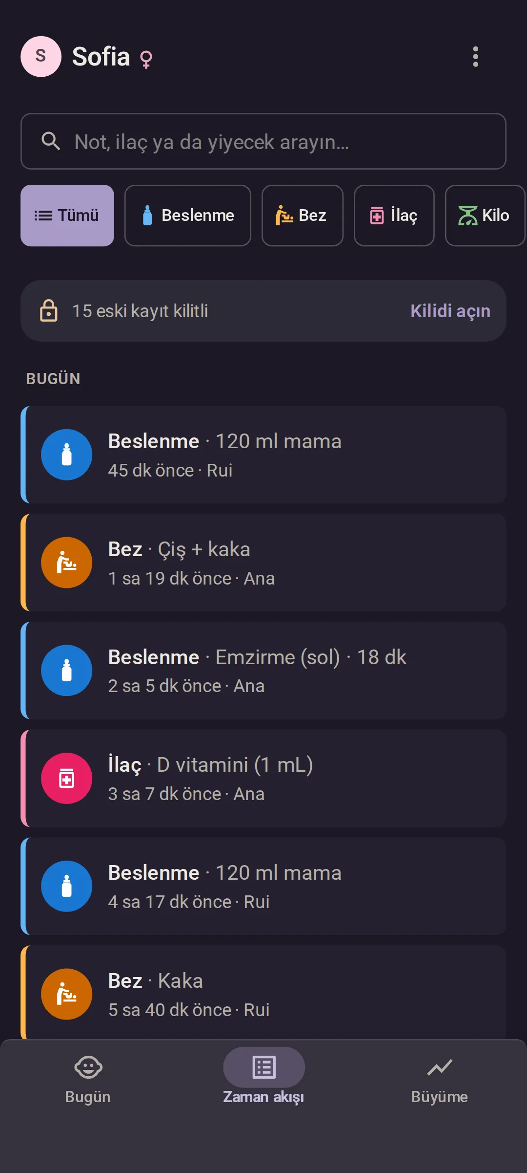 Ana’nın telefonu, karanlık modda: bugünün Zaman akışı, en yenisi en üstte, her kayıtta onu girenin adıyla. 45 dakika önce 120 ml mama (Rui), 1 saat 19 dakika önce çişli ve kakalı bir bez (Ana), 2 saat 5 dakika önce 18 dakikalık emzirme (Ana) ve 3 saat 7 dakika önce D vitamini (Ana).